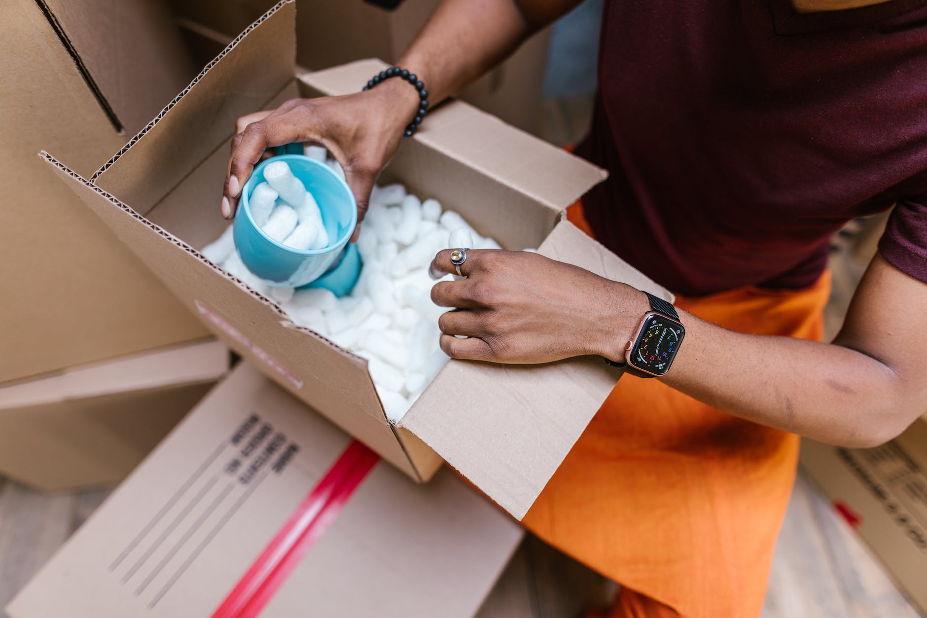 high angle view of man packing cardboard boxes with protection foam